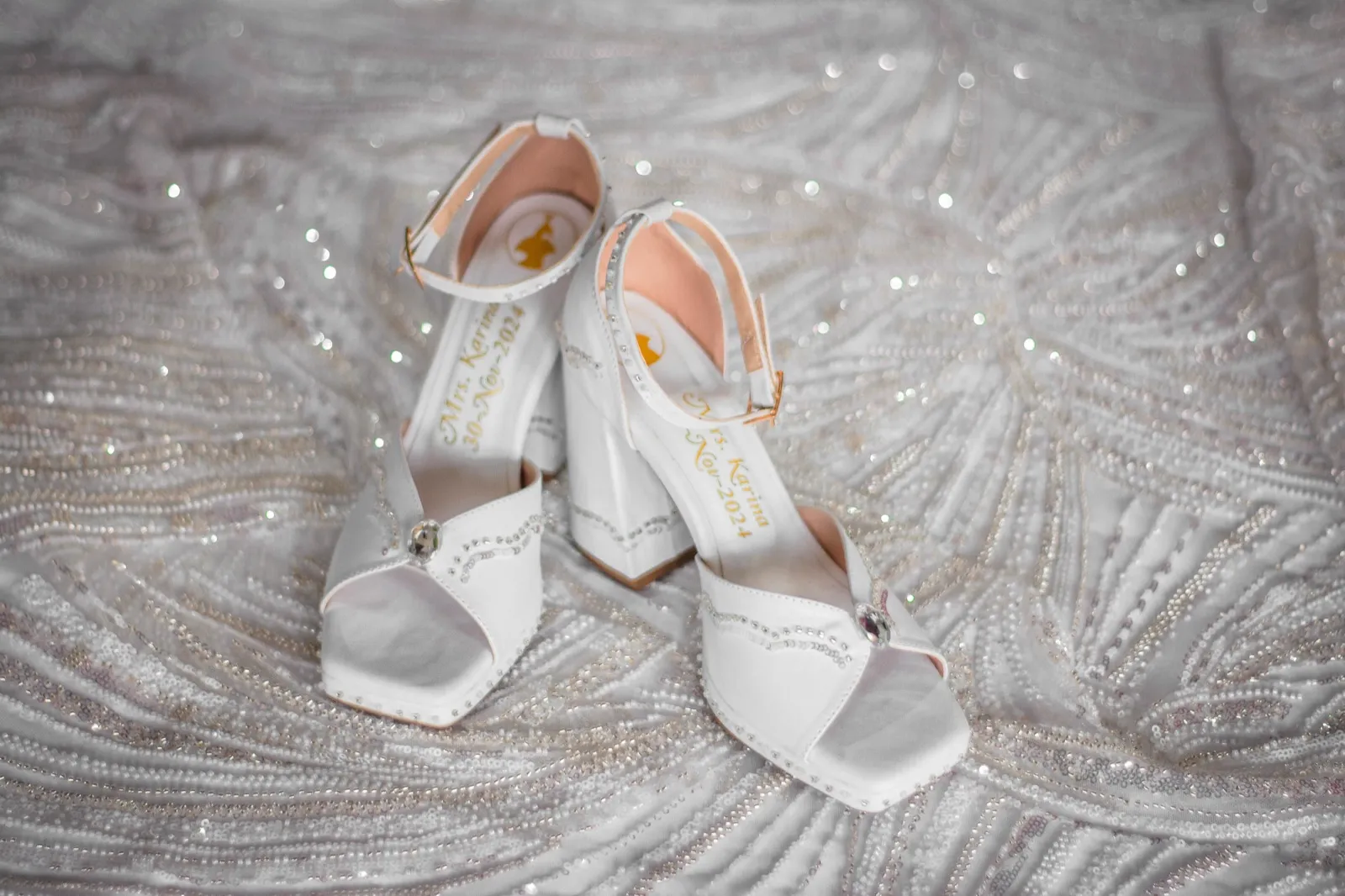 Zapatos blancos de tacón sobre tela con pedrería